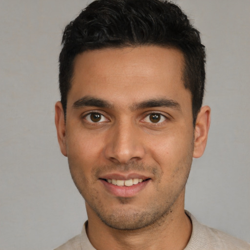 Joyful white young-adult male with short  black hair and brown eyes