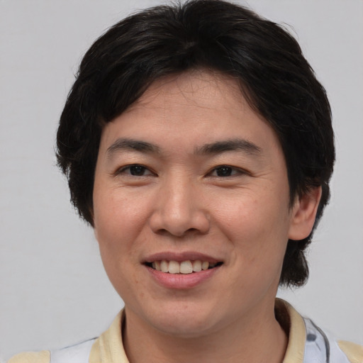 Joyful asian young-adult male with medium  brown hair and brown eyes