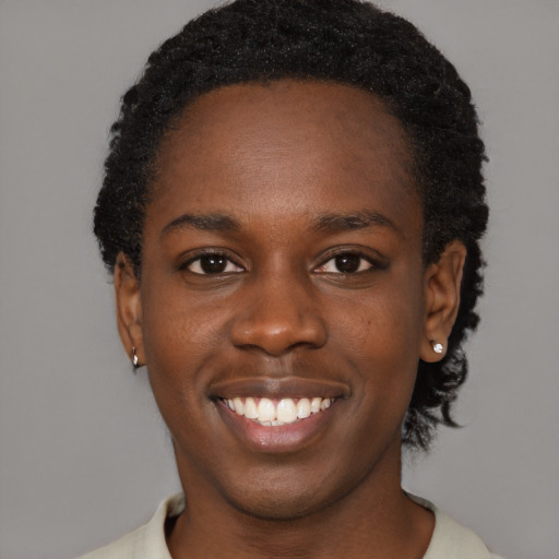 Joyful black young-adult female with short  black hair and brown eyes