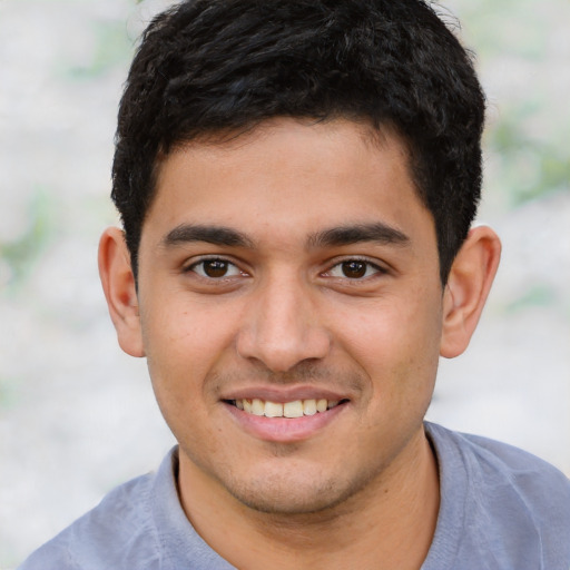 Joyful latino young-adult male with short  brown hair and brown eyes