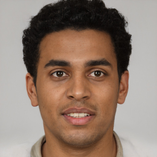 Joyful latino young-adult male with short  brown hair and brown eyes