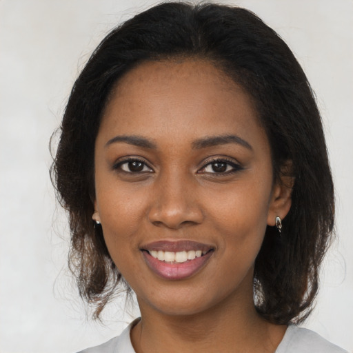 Joyful black young-adult female with medium  brown hair and brown eyes