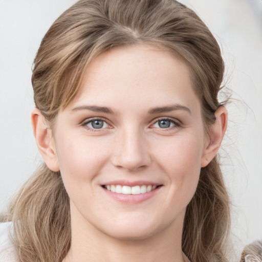 Joyful white young-adult female with medium  brown hair and grey eyes