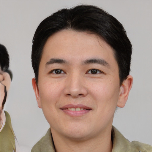 Joyful asian young-adult male with short  black hair and brown eyes