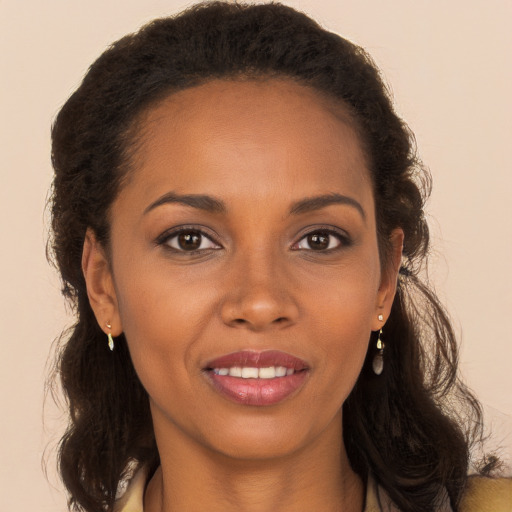 Joyful black young-adult female with long  brown hair and brown eyes