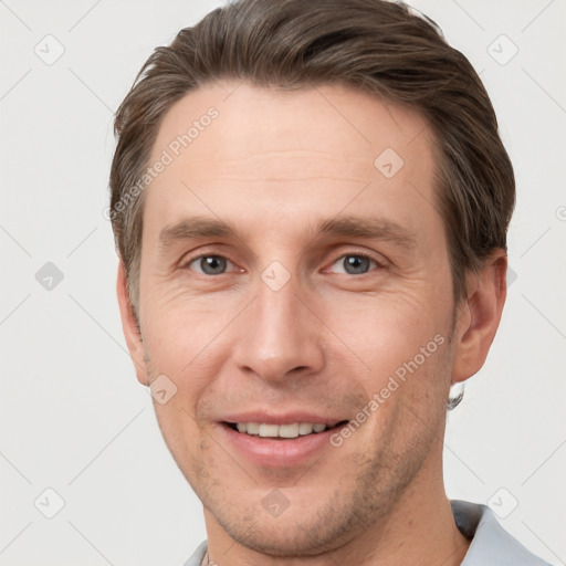 Joyful white adult male with short  brown hair and grey eyes