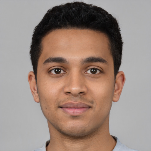 Joyful latino young-adult male with short  black hair and brown eyes