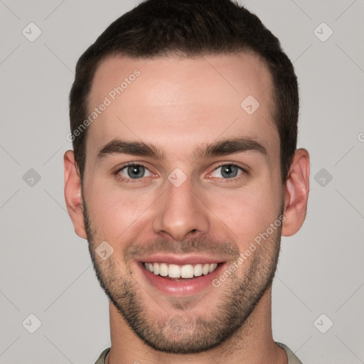 Joyful white young-adult male with short  brown hair and grey eyes