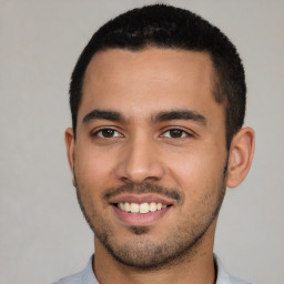 Joyful latino young-adult male with short  black hair and brown eyes