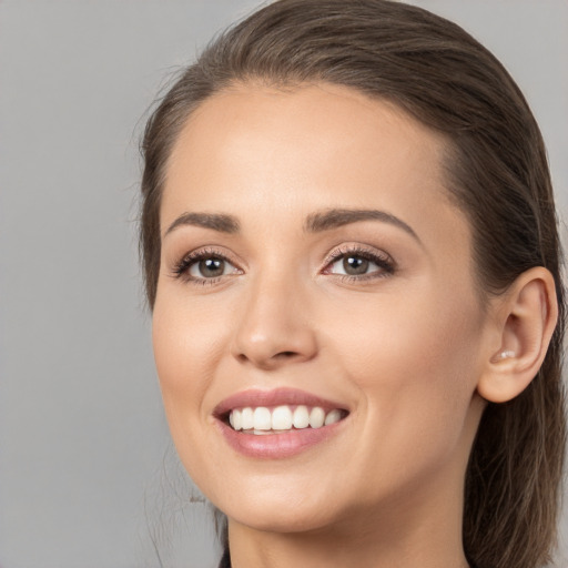 Joyful white young-adult female with long  brown hair and brown eyes