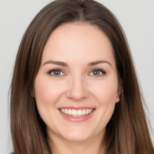 Joyful white young-adult female with long  brown hair and brown eyes