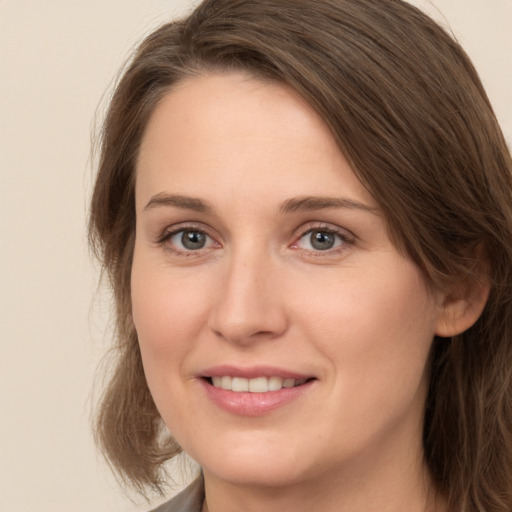 Joyful white young-adult female with medium  brown hair and grey eyes