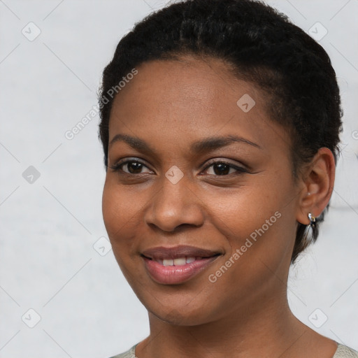 Joyful black young-adult female with short  black hair and brown eyes