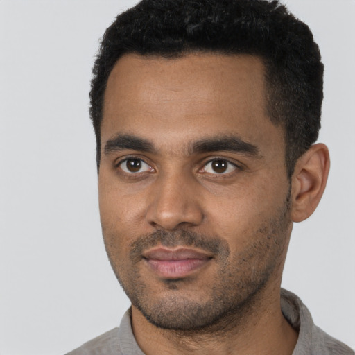 Joyful black young-adult male with short  black hair and brown eyes