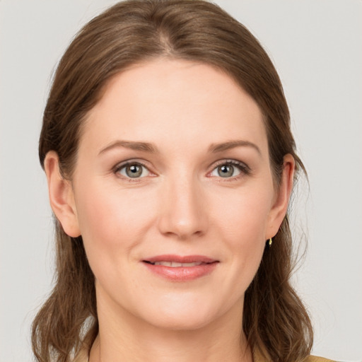 Joyful white young-adult female with medium  brown hair and grey eyes