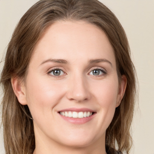 Joyful white young-adult female with medium  brown hair and green eyes