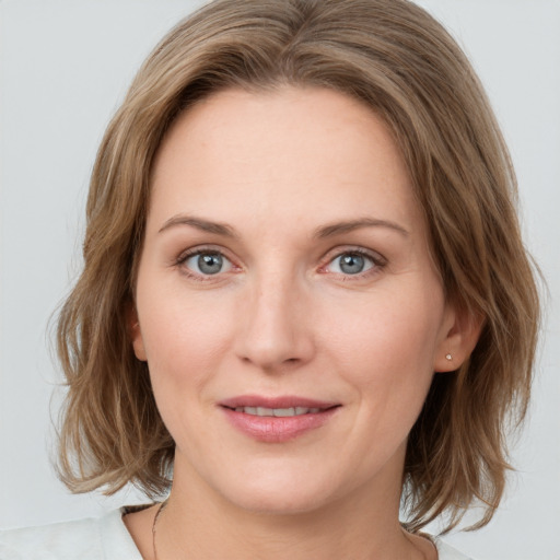 Joyful white young-adult female with medium  brown hair and green eyes