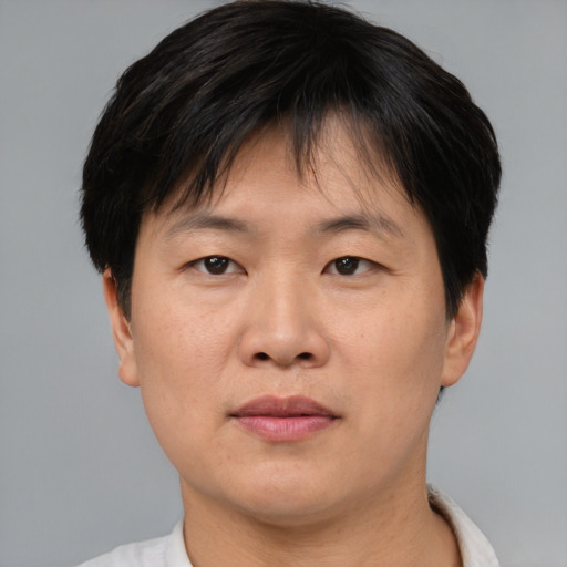 Joyful asian adult male with short  brown hair and brown eyes