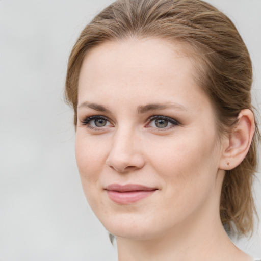 Joyful white young-adult female with medium  brown hair and grey eyes