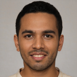 Joyful latino young-adult male with short  black hair and brown eyes