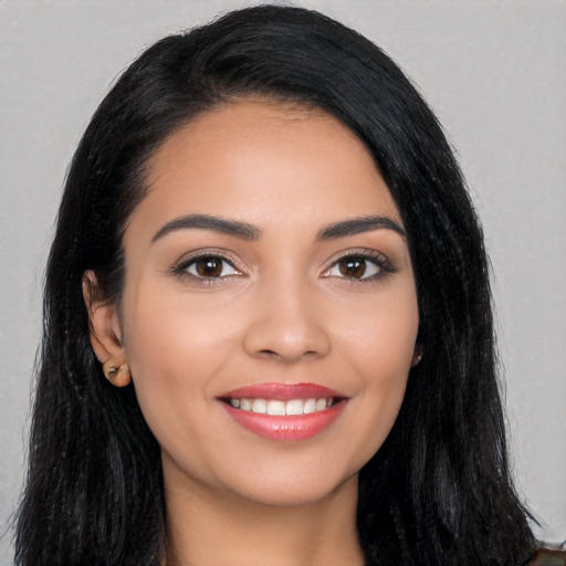 Joyful latino young-adult female with long  black hair and brown eyes