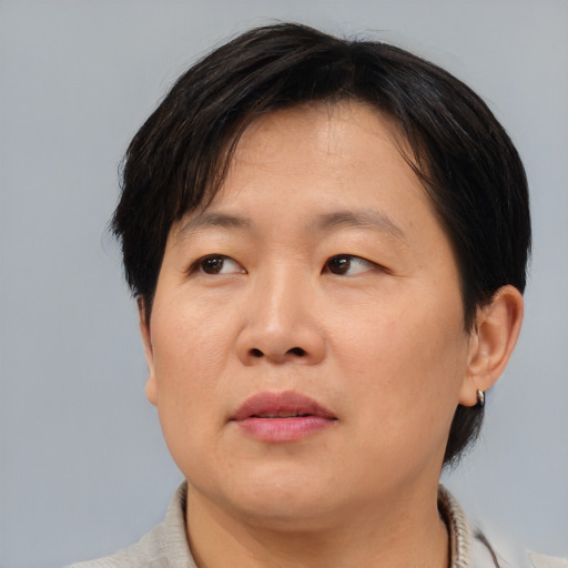 Joyful asian adult female with medium  brown hair and brown eyes