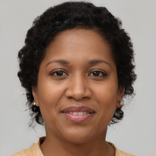Joyful black young-adult female with short  brown hair and brown eyes
