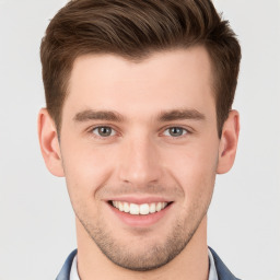 Joyful white young-adult male with short  brown hair and grey eyes