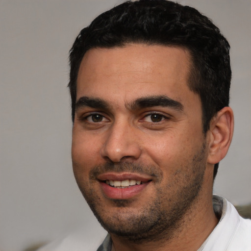 Joyful white young-adult male with short  black hair and brown eyes