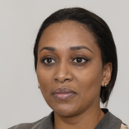 Joyful black adult female with medium  black hair and brown eyes