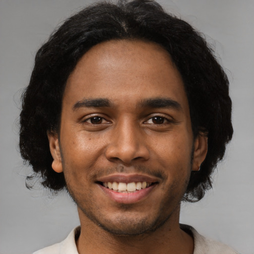 Joyful black young-adult male with short  black hair and brown eyes