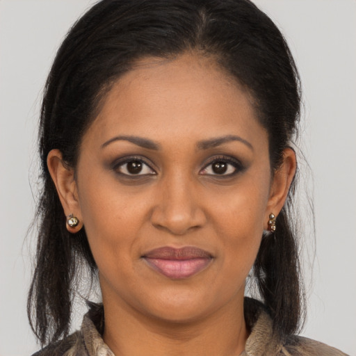 Joyful black adult female with long  brown hair and brown eyes