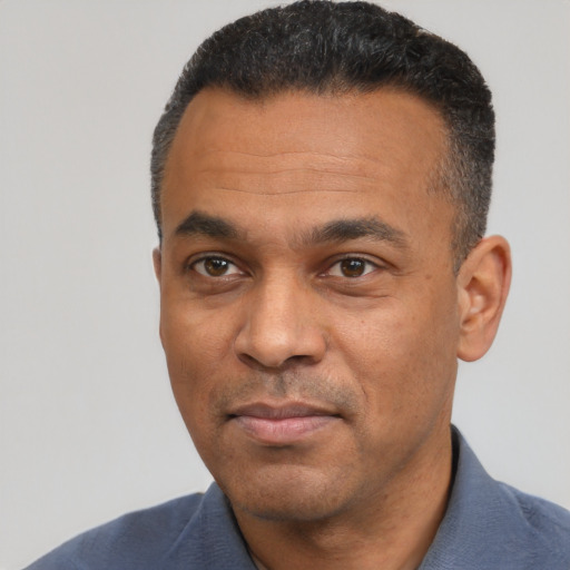 Joyful latino adult male with short  black hair and brown eyes