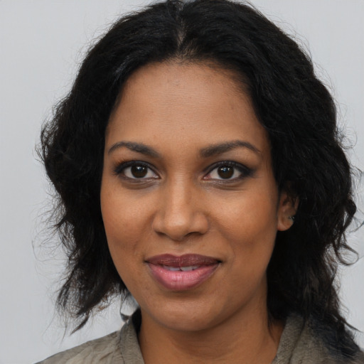 Joyful black adult female with long  brown hair and brown eyes