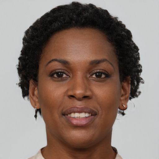 Joyful black young-adult female with short  brown hair and brown eyes