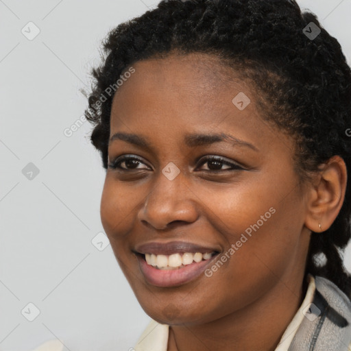 Joyful black young-adult female with short  brown hair and brown eyes