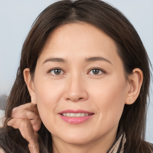 Joyful white young-adult female with long  brown hair and brown eyes