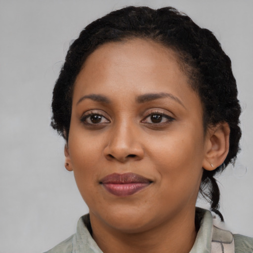 Joyful black adult female with short  black hair and brown eyes