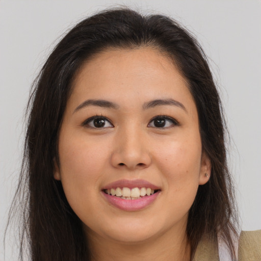 Joyful latino young-adult female with long  brown hair and brown eyes