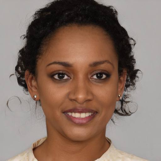 Joyful black young-adult female with short  brown hair and brown eyes