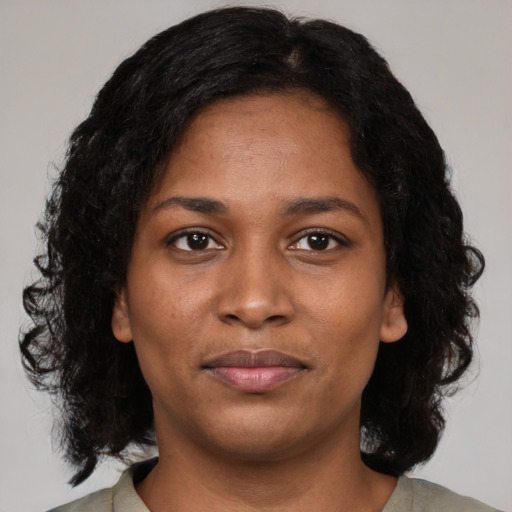 Joyful black young-adult female with medium  brown hair and brown eyes