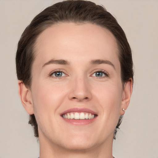 Joyful white young-adult female with short  brown hair and grey eyes