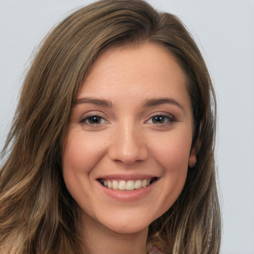 Joyful white young-adult female with long  brown hair and brown eyes