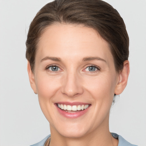 Joyful white young-adult female with short  brown hair and grey eyes