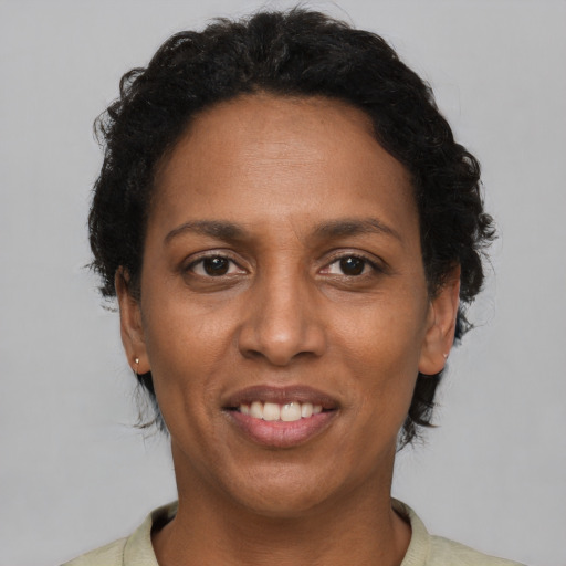 Joyful black adult female with short  brown hair and brown eyes