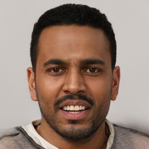Joyful black young-adult male with short  black hair and brown eyes