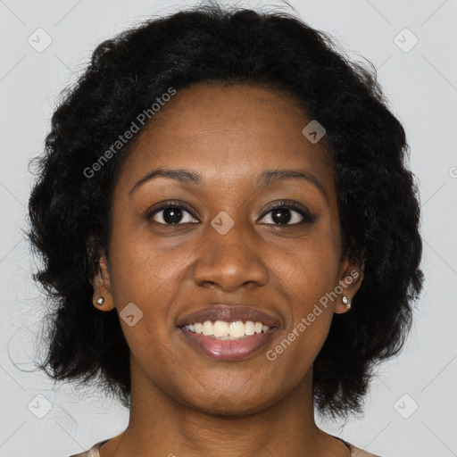 Joyful black young-adult female with long  black hair and brown eyes