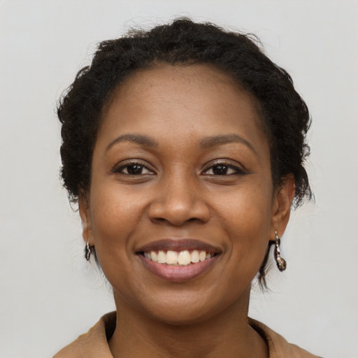 Joyful black young-adult female with long  brown hair and brown eyes