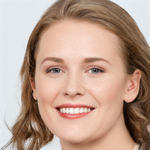 Joyful white young-adult female with long  brown hair and blue eyes