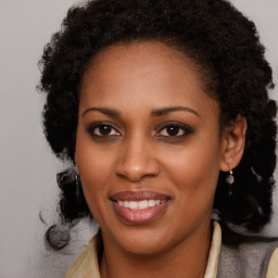 Joyful black young-adult female with long  brown hair and brown eyes